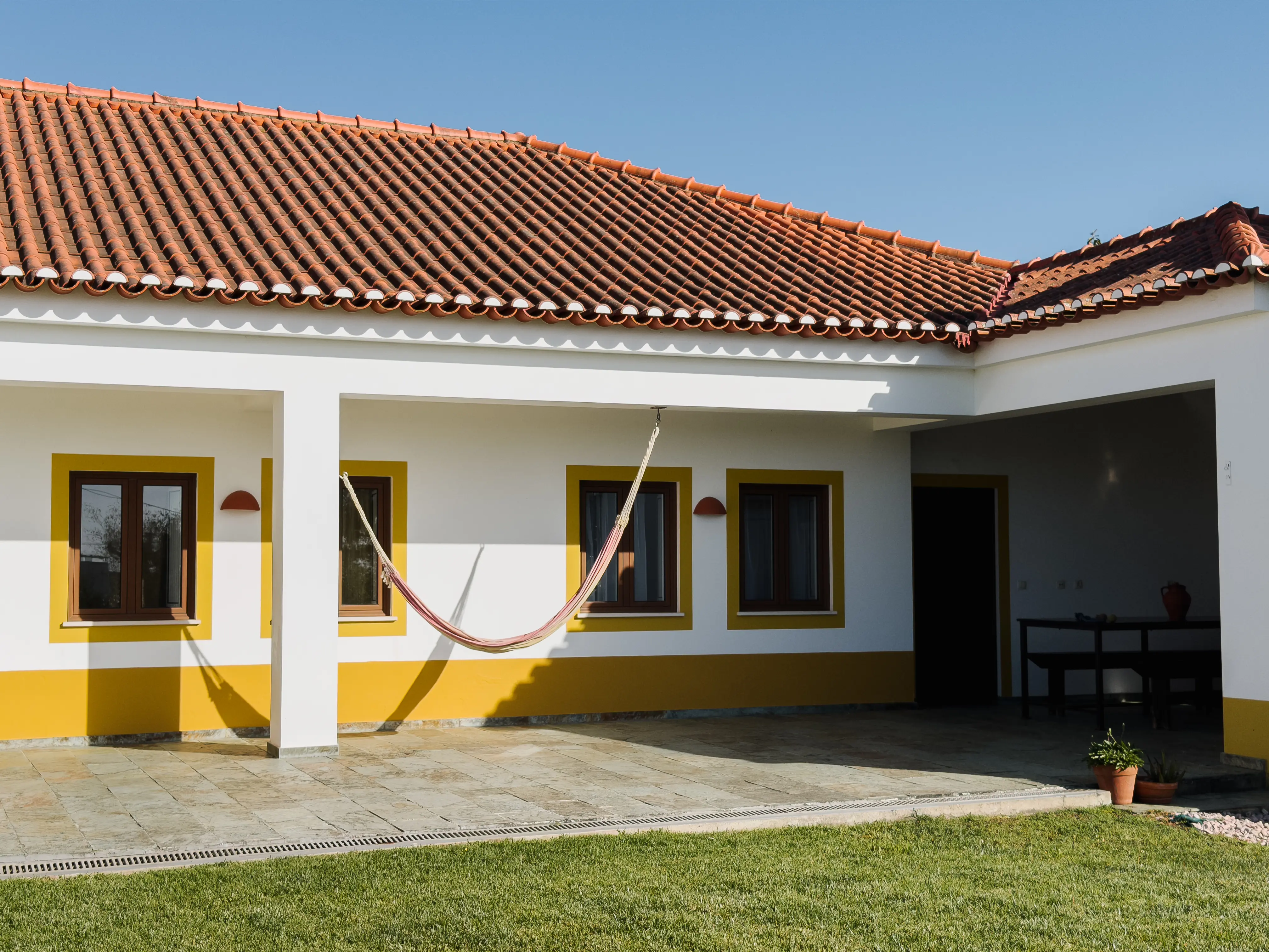 Pátio exterior da Quinta dos Citrinos com mobília de jardim e citrinos