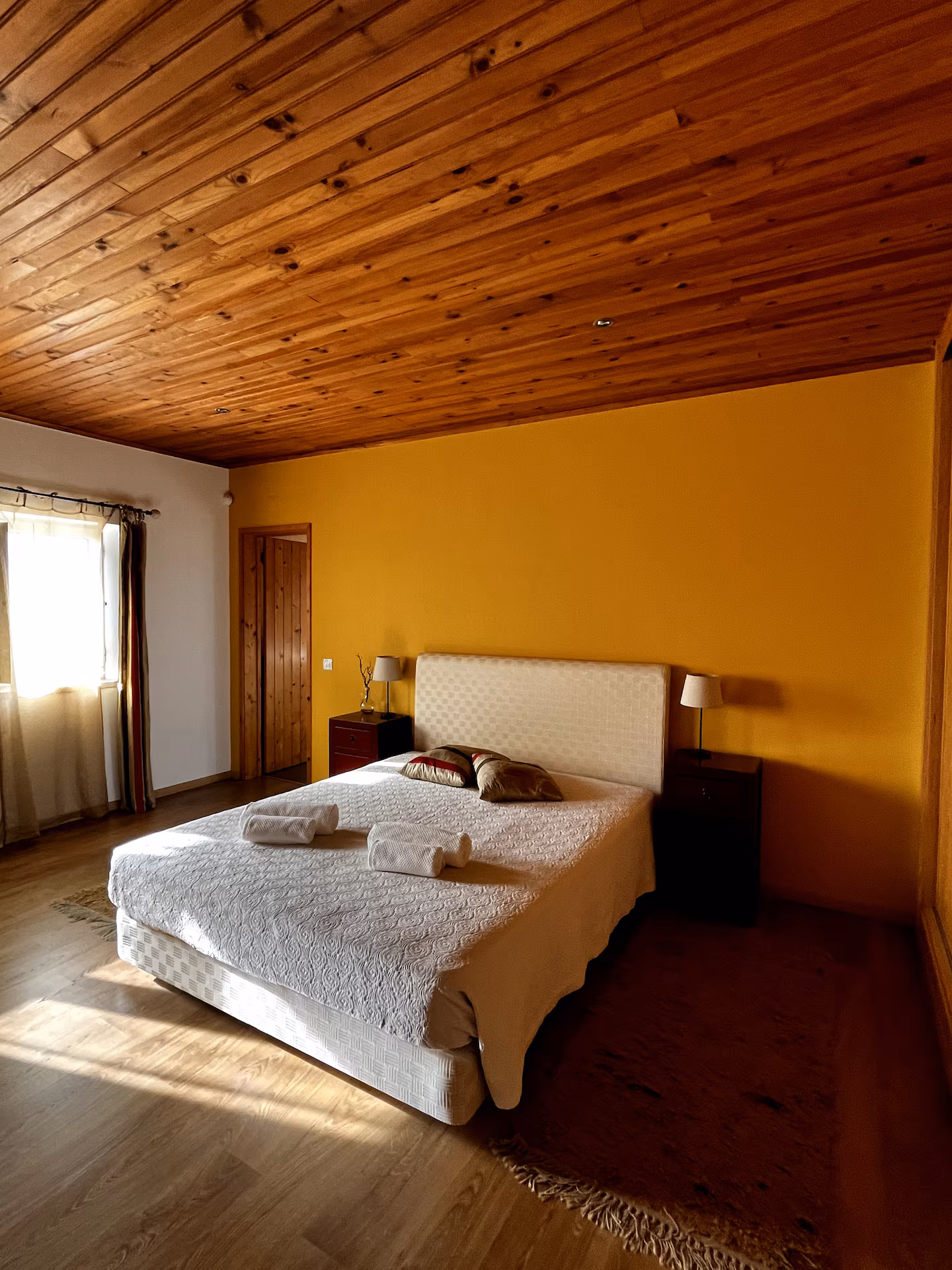 Quarto principal da Quinta dos Citrinos com cama de casal e luz natural