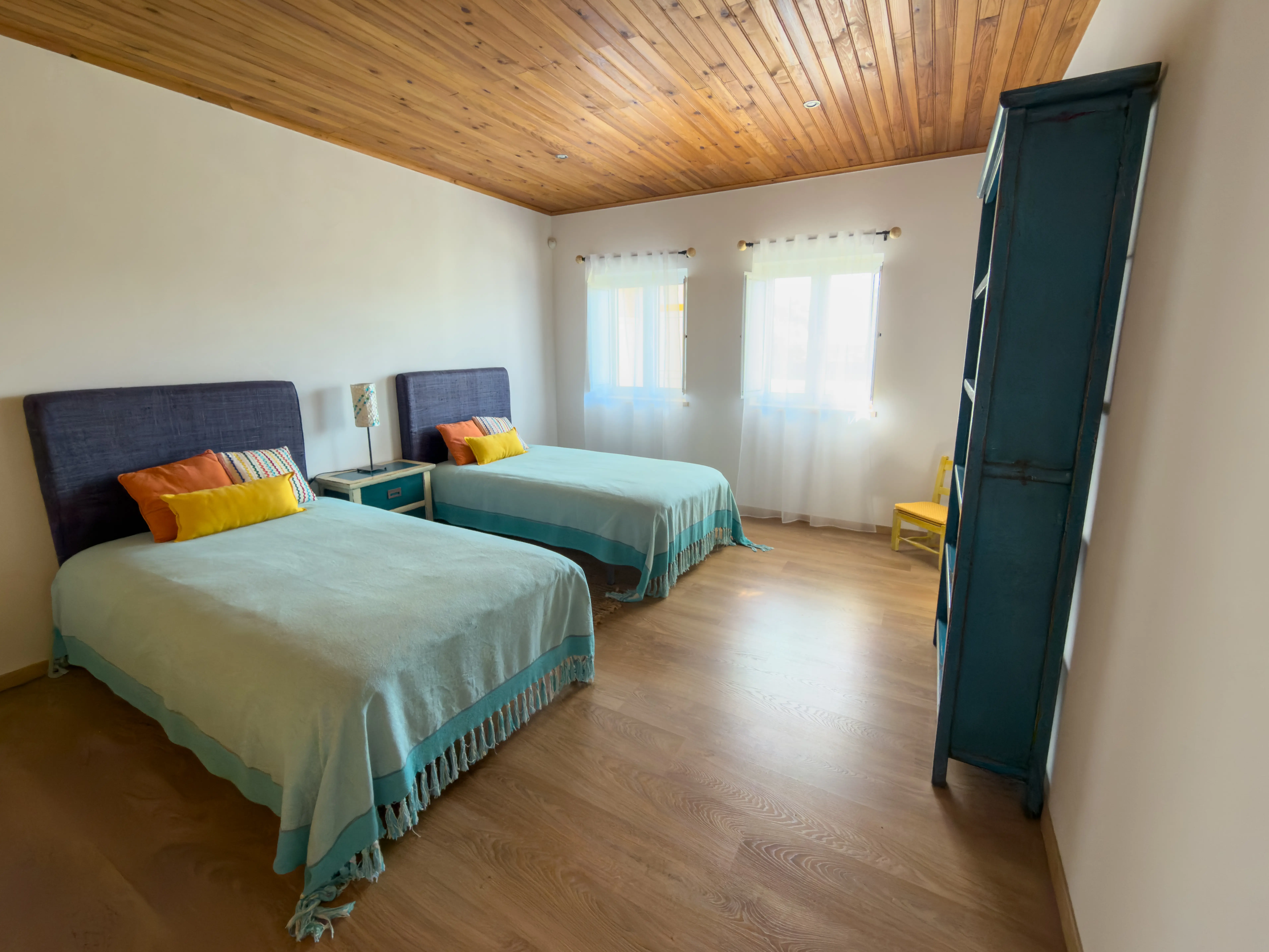 Quarto individual da Quinta dos Citrinos com estante de livros e ambiente sereno